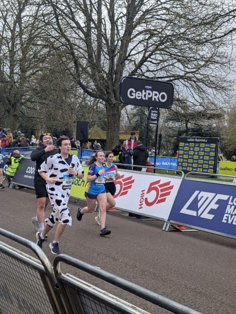 Preston running the Bath Half Marathon in a black-and-white cow costume