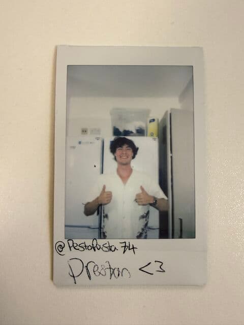 A Polaroid of Preston smiling and giving two thumbs up on his first day at university