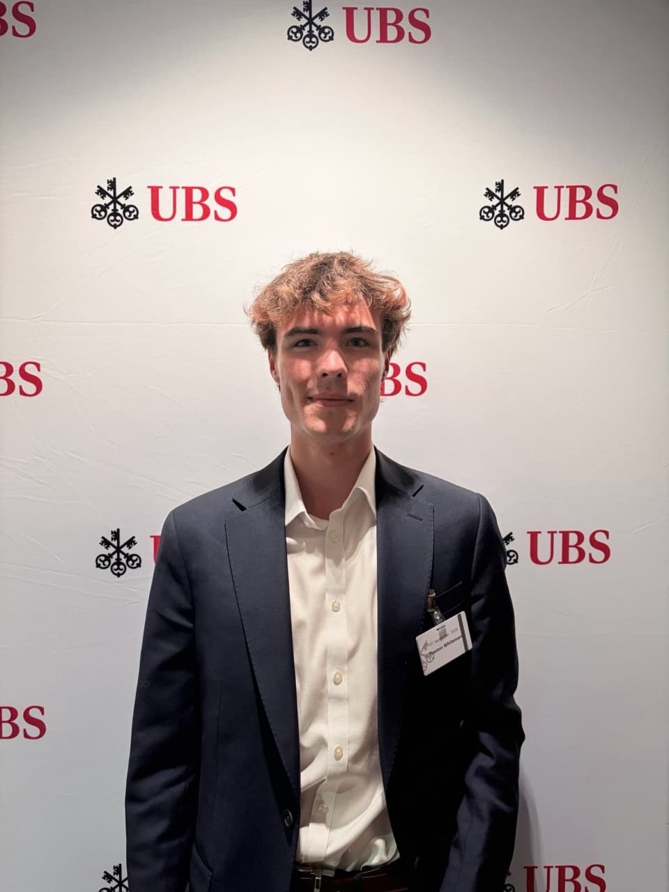 Portrait in a suit in front of a UBS backdrop